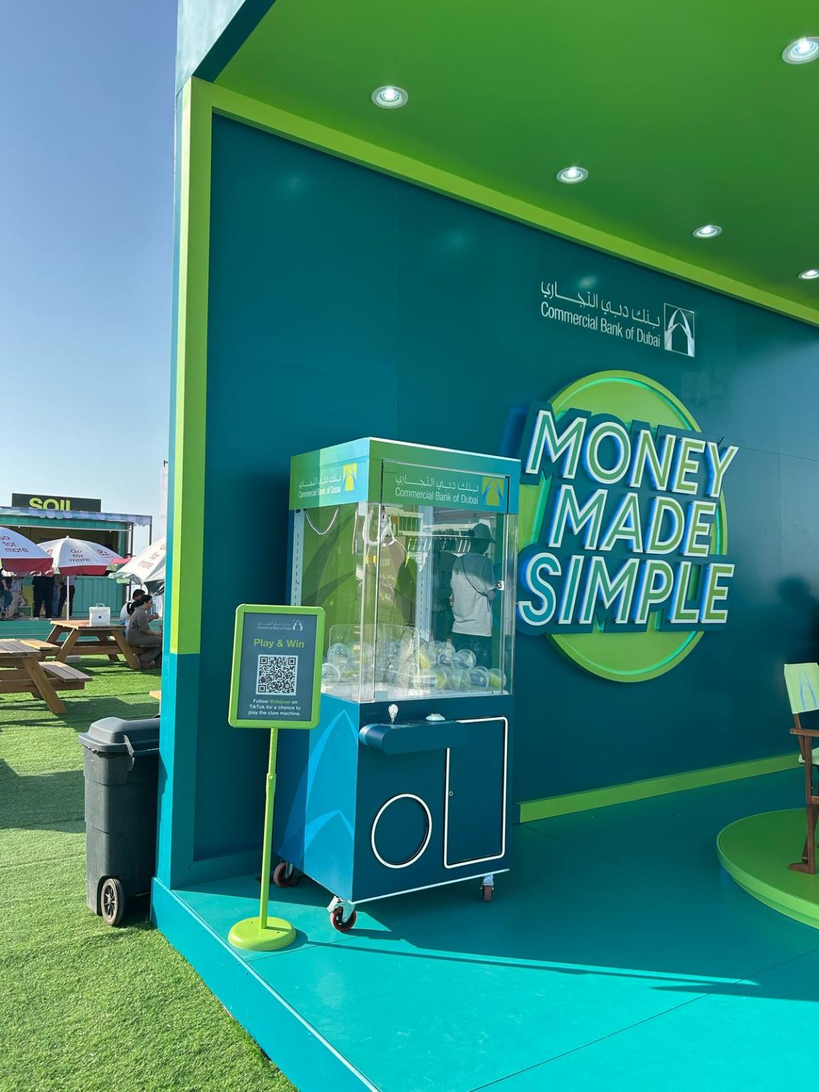 Custom branded claw machine rental at a corporate event activation in Dubai, UAE, engaging a crowd of participants.