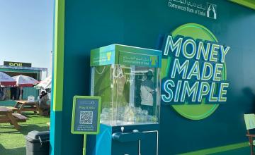 Custom branded claw machine rental at a corporate event activation in Dubai, UAE, engaging a crowd of participants.