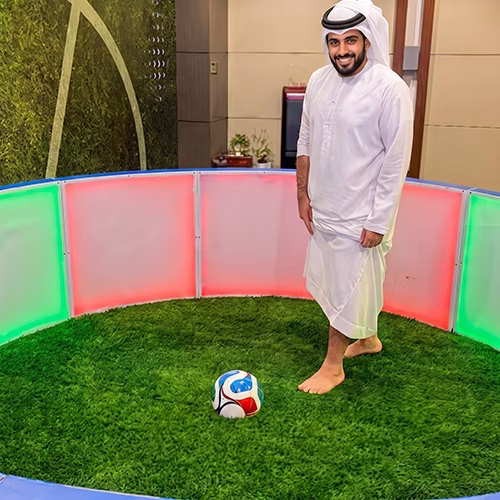Custom-branded Interactive Football Arena setup at a Dubai exhibition venue with an electronic leaderboard for competition