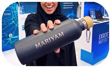 Close-up of a high-speed laser engraving machine personalizing a luxury perfume bottle at a premium event in Dubai.