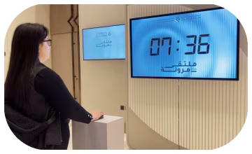Guests playing Stop the Time interactive stopwatch game at a corporate event booth in Dubai, engaging with branded screen and trying to press the button at the perfect moment
